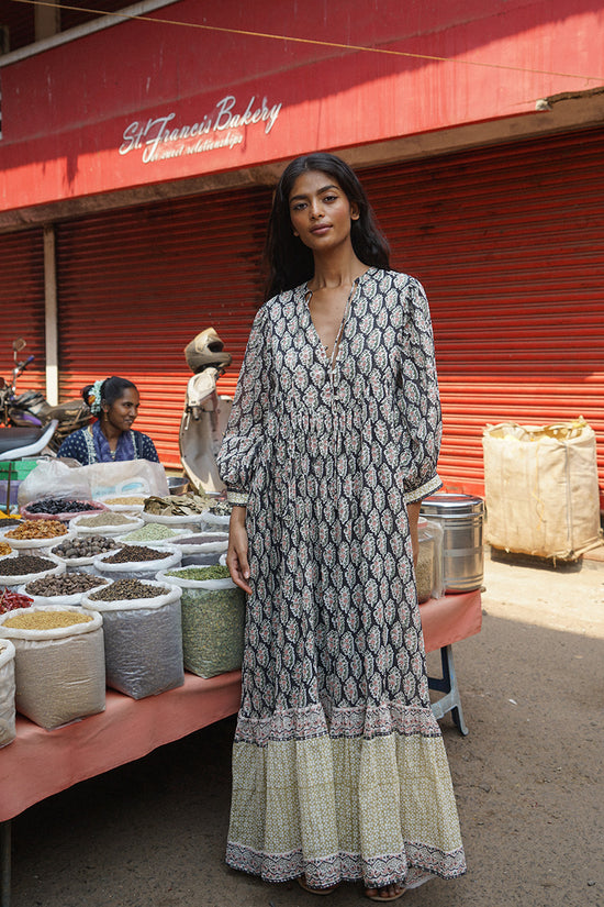 Bhoomi Maxi Dress Onyx — full length front view at Indian spice market, onyx hand block print maxi dress with V-neckline and tiered hem, colourful spice stall India | Daughters of India