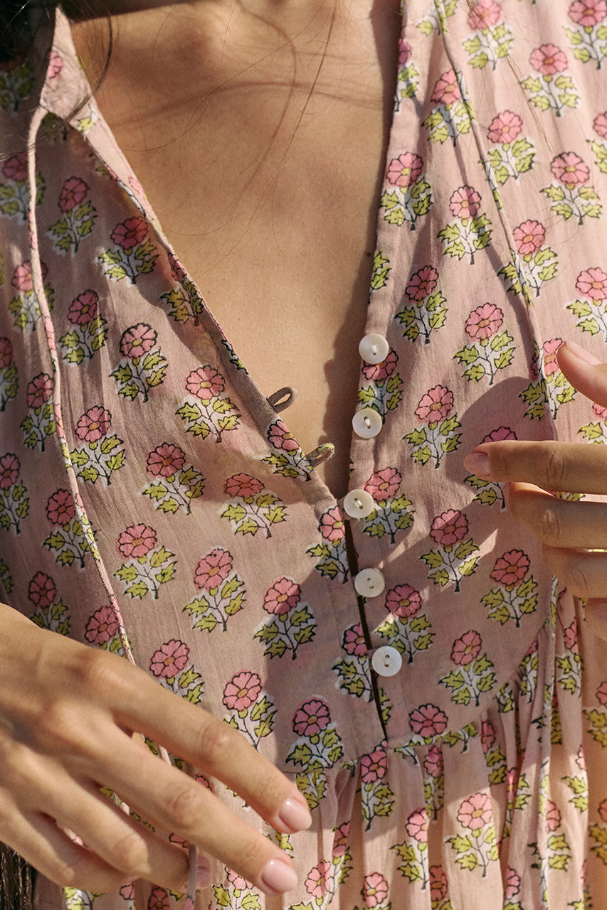 Close-up detail of the Daughters of India Bhoomi Mini Dress in Sunset, showing the floral block print fabric and button placket at the V-neckline