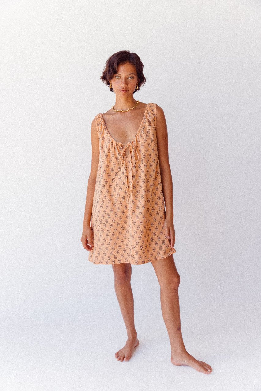 Sundress Mini Peach — model twirling showing skirt movement, peach cotton block print mini sundress, sleeveless short sundress, effortless summer style, artisan made India | Daughters of India