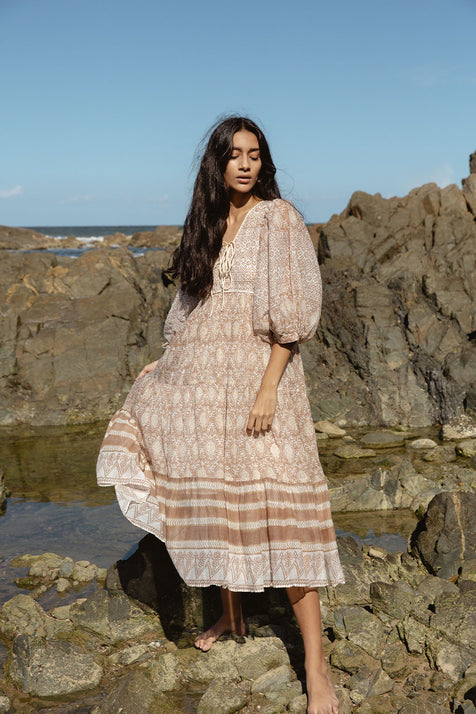 Daughters of India Jasmine Midi Dress in Shell — full length on rocky shore, hand screen print cotton with balloon sleeves